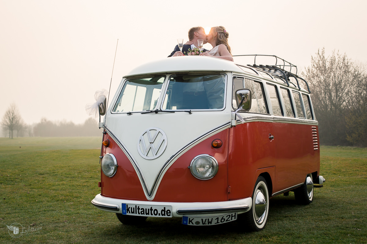 VW Bus mit Hochzeitspaar auf Golfplatz